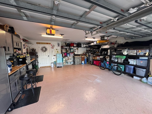 garage with a garage door opener and a workshop area