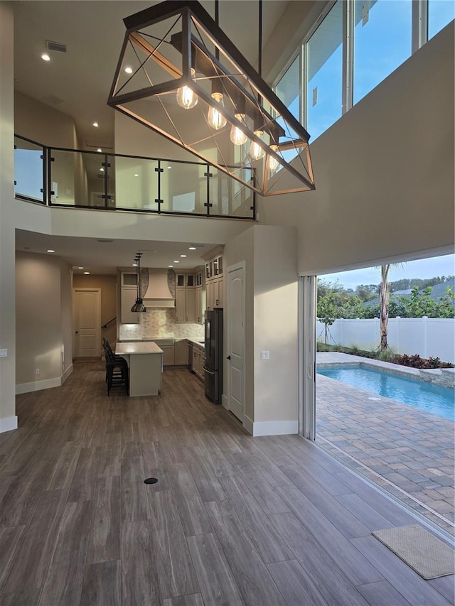 kitchen featuring dark wood-style floors, light countertops, decorative backsplash, freestanding refrigerator, and open floor plan