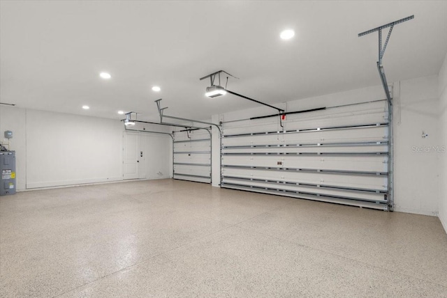 garage featuring recessed lighting, electric water heater, and a garage door opener