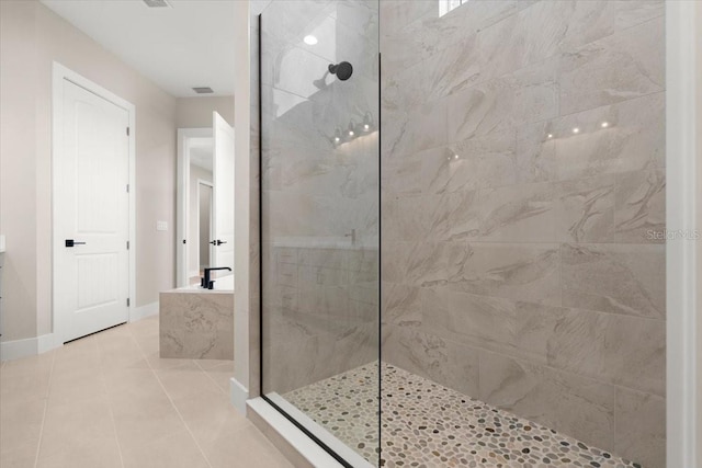 bathroom with a walk in shower, tile patterned floors, and baseboards