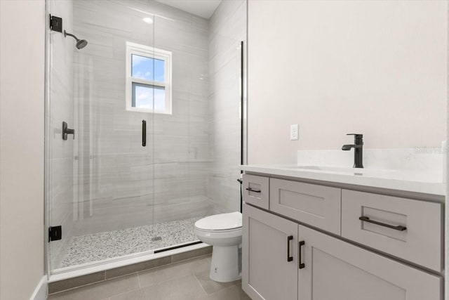 full bath with a stall shower, tile patterned flooring, vanity, and toilet