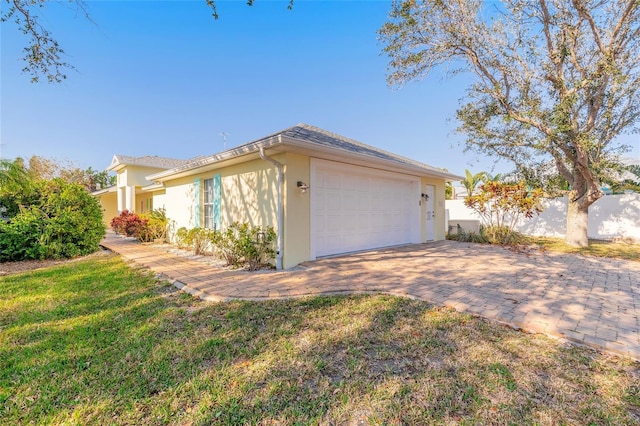 view of side of property featuring a garage and a lawn