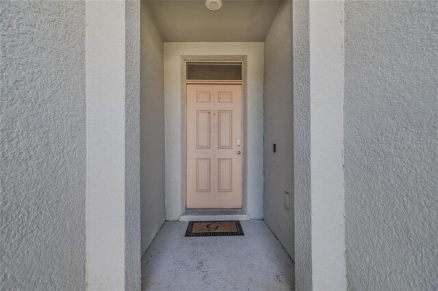 view of exterior entry with stucco siding