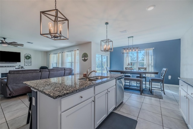 kitchen featuring a kitchen island with sink, white cabinets, dishwasher, and open floor plan