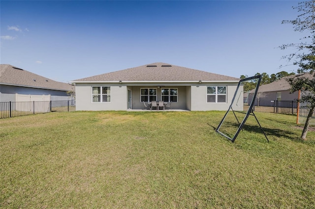 rear view of property with a yard, a fenced backyard, and stucco siding