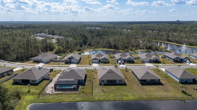 drone / aerial view featuring a residential view, a water view, and a forest view