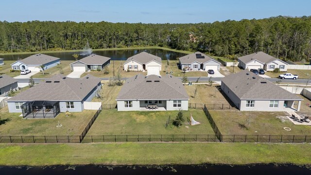 drone / aerial view featuring a water view, a residential view, and a view of trees