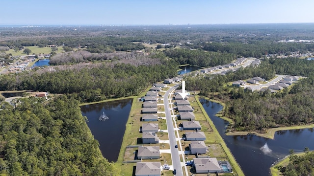 drone / aerial view featuring a water view, a residential view, and a wooded view