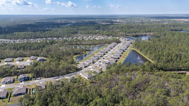 birds eye view of property featuring a water view and a view of trees