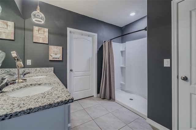 full bath featuring a stall shower, a sink, and tile patterned floors