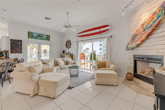 living room with rail lighting, light tile patterned floors, a fireplace, and french doors
