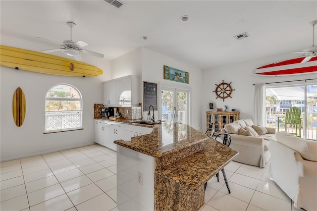 kitchen with sink, ceiling fan, backsplash, white cabinets, and light tile patterned flooring