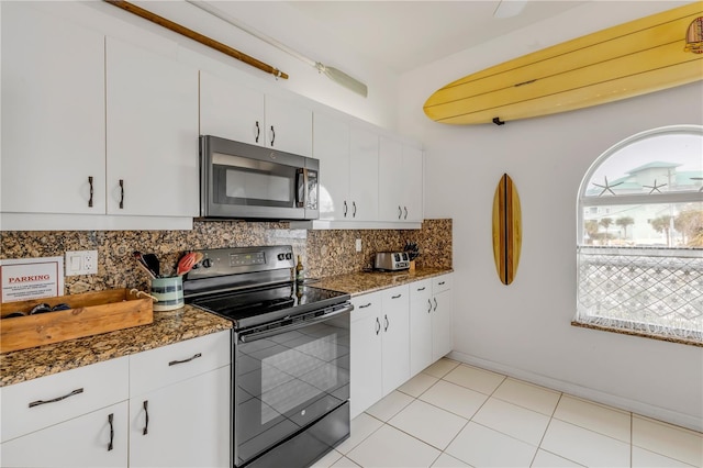 kitchen featuring tasteful backsplash, dark stone countertops, white cabinets, and black range with electric cooktop