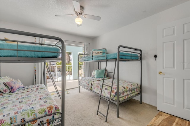 bedroom with ceiling fan, access to outside, and a textured ceiling