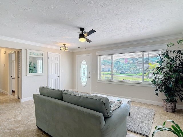 living room with ceiling fan, ornamental molding, light tile patterned flooring, and a textured ceiling