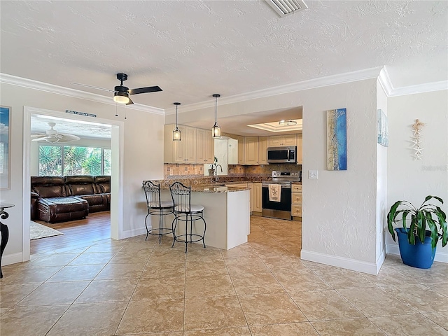 kitchen featuring kitchen peninsula, a textured ceiling, appliances with stainless steel finishes, crown molding, and a kitchen bar