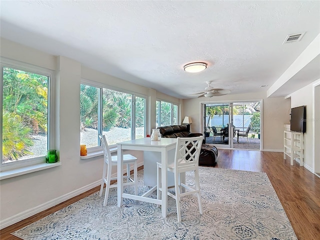 dining area featuring a textured ceiling, hardwood / wood-style flooring, and ceiling fan