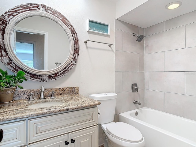 full bathroom with vanity, tiled shower / bath, and toilet