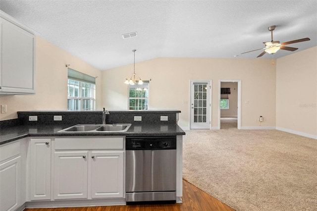 kitchen with lofted ceiling, sink, stainless steel dishwasher, and white cabinets