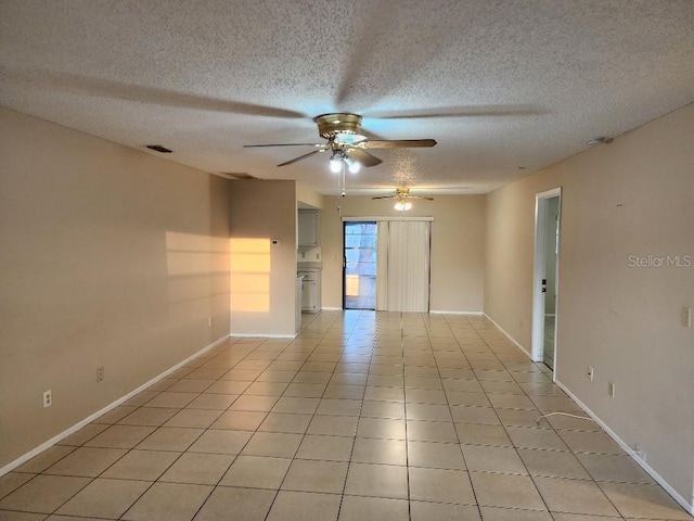 tiled spare room featuring a textured ceiling and ceiling fan