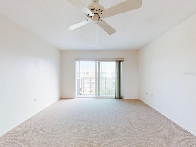 empty room featuring a ceiling fan and light carpet