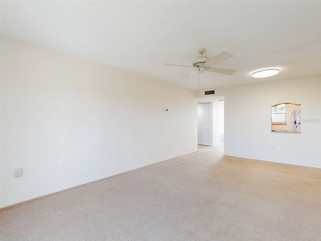 spare room with ceiling fan, visible vents, and light colored carpet