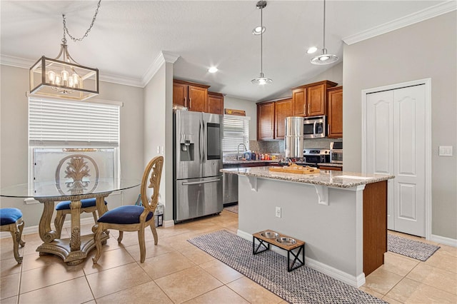 kitchen with light stone counters, stainless steel appliances, a kitchen breakfast bar, brown cabinetry, and crown molding