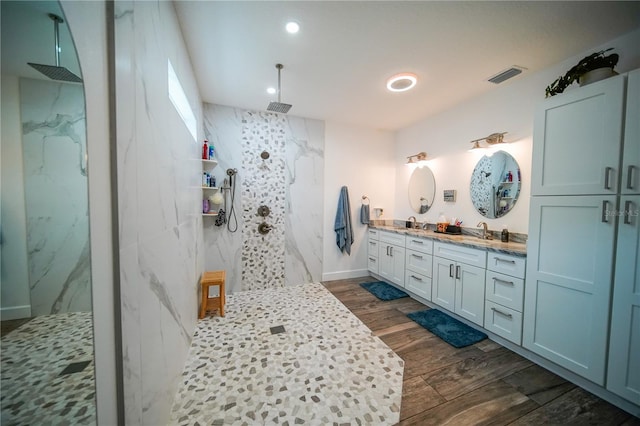 bathroom featuring a tile shower and vanity