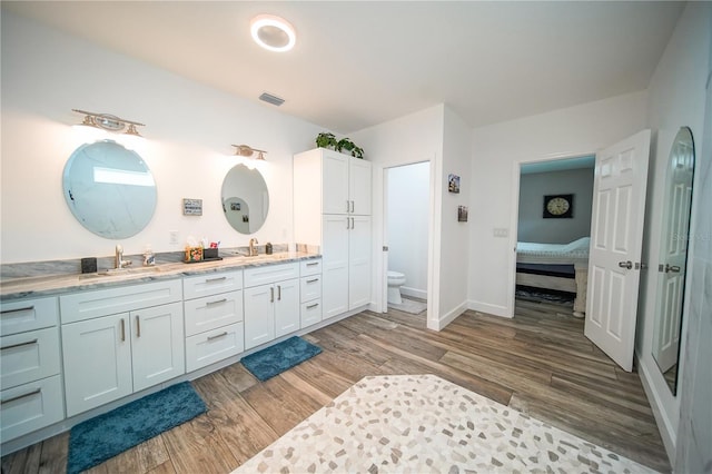 bathroom with toilet, hardwood / wood-style flooring, and vanity