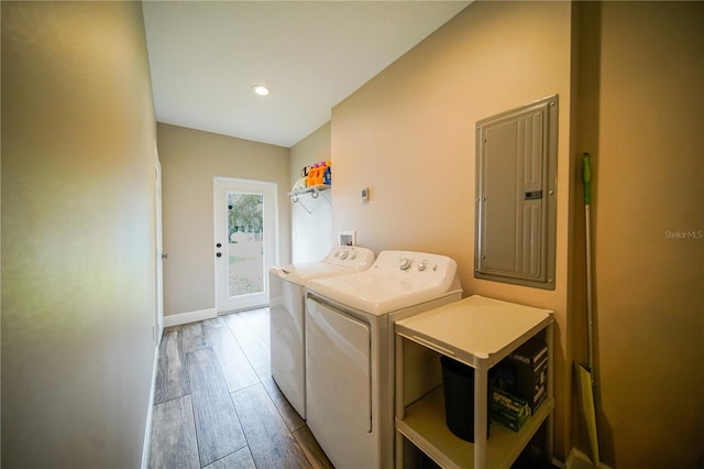 laundry area featuring washer and dryer, electric panel, and wood-type flooring