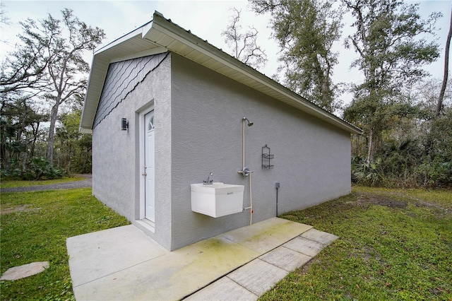 view of property exterior featuring a patio and a yard