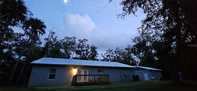 back of house with cooling unit, a lawn, and a wooden deck