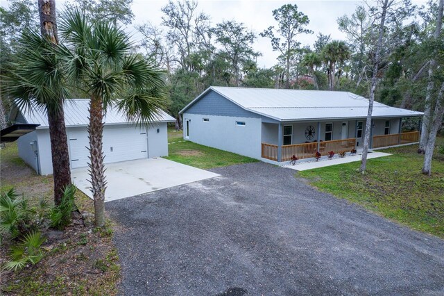 view of front of property with covered porch, a front lawn, and a garage