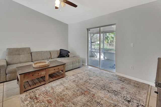 living area featuring light tile patterned floors, ceiling fan, and baseboards