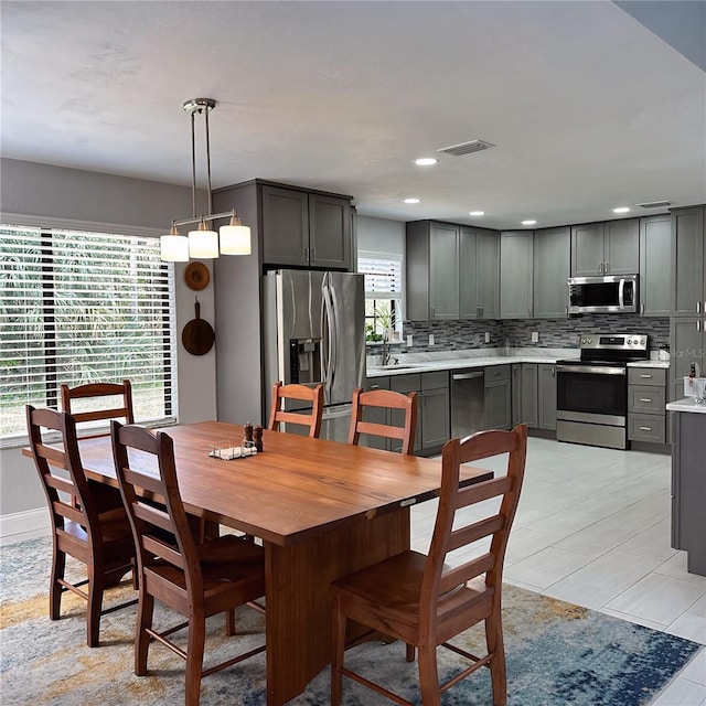 dining room with light tile patterned flooring, plenty of natural light, and sink