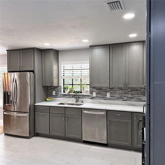 kitchen with stainless steel appliances, sink, and decorative backsplash