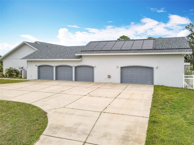 view of front facade featuring a garage, a front yard, and solar panels