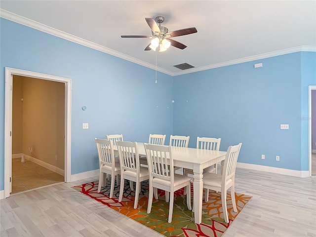 dining area with ceiling fan, ornamental molding, and light wood-type flooring