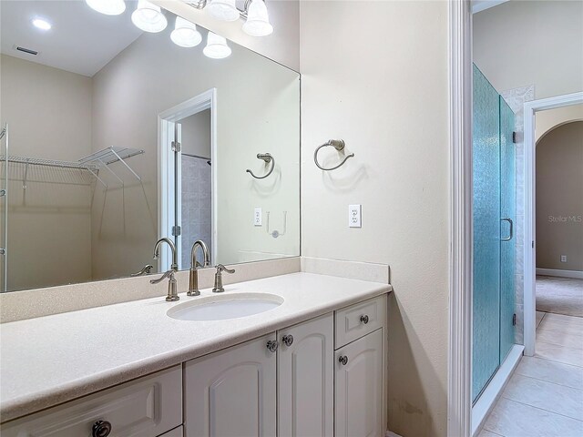 bathroom with vanity, a shower with shower door, and tile patterned floors