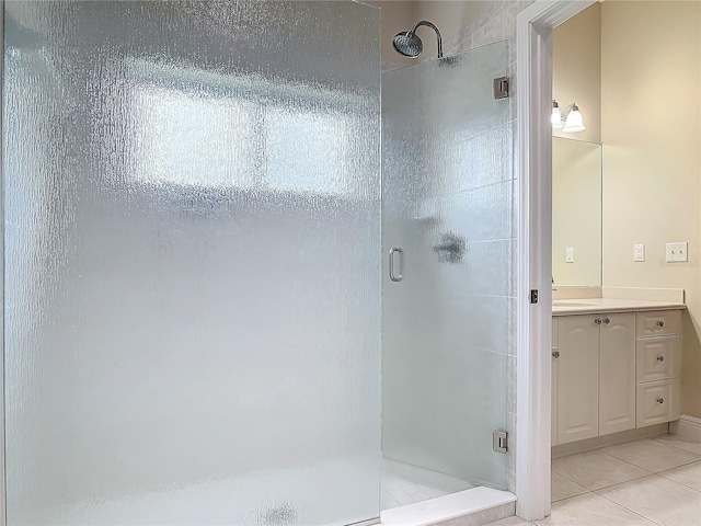 bathroom featuring tile patterned flooring, vanity, and a shower with shower door