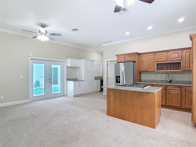 kitchen with french doors, a center island, ornamental molding, ceiling fan, and stainless steel appliances