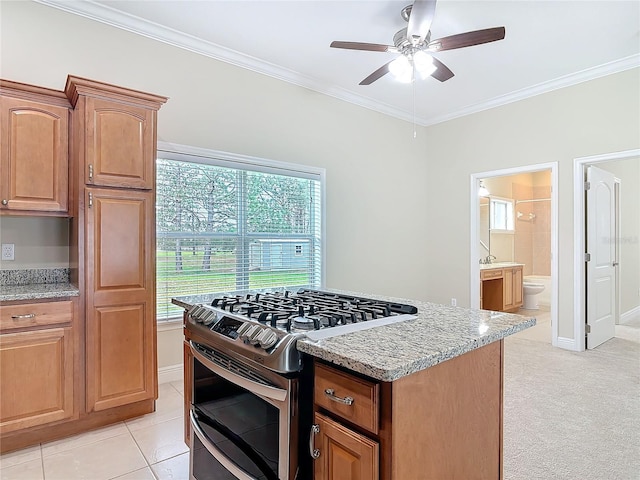 kitchen featuring double oven range, light stone countertops, plenty of natural light, and ornamental molding