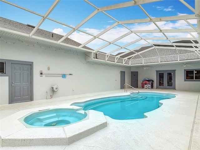 view of pool with ceiling fan, glass enclosure, a patio area, french doors, and an in ground hot tub