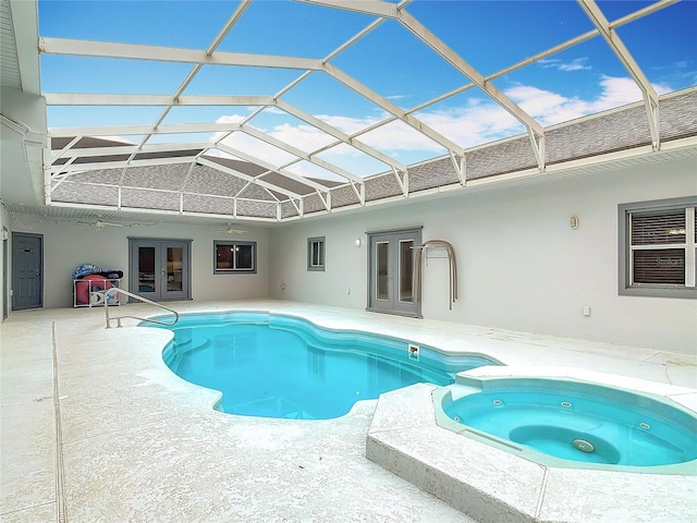 view of swimming pool with french doors, an in ground hot tub, a lanai, and a patio area