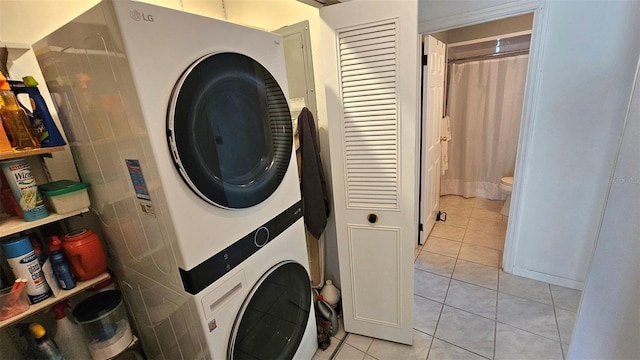 26 Birdie Dr, New Smyrna Beach, FL 32168 - laundry area featuring stacked washer and dryer, laundry area, and light tile patterned flooring