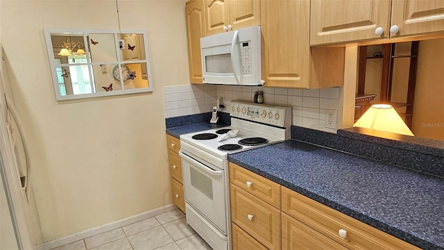 26 Birdie Dr, New Smyrna Beach, FL 32168 - kitchen featuring light tile patterned flooring, white appliances, baseboards, tasteful backsplash, and dark countertops