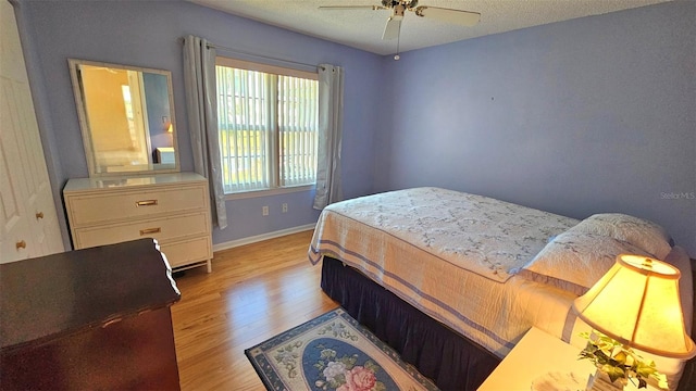 26 Birdie Dr, New Smyrna Beach, FL 32168 - bedroom with light wood-style flooring, a textured ceiling, baseboards, and a ceiling fan