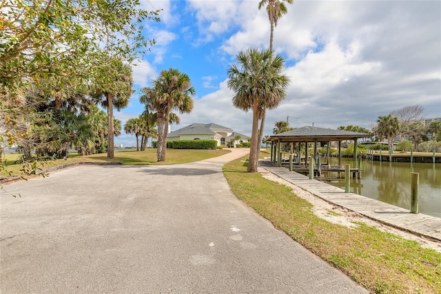 view of dock with a lawn and a water view