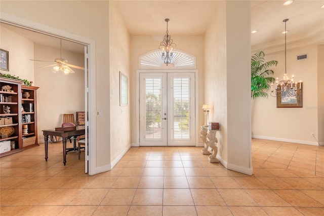 foyer entrance featuring french doors, light tile patterned floors, visible vents, a towering ceiling, and baseboards