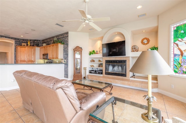 living area with light tile patterned floors, baseboards, visible vents, a fireplace, and recessed lighting